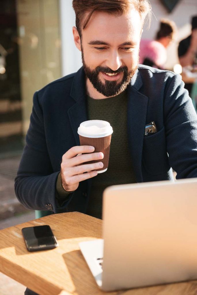 Man working on computer with coffee